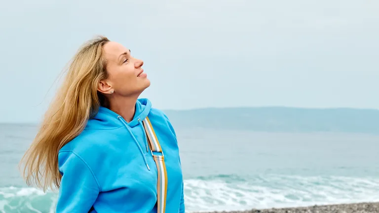 Woman taking a calm morning breath by the ocean — anxiety and depression therapy in Palm Beach Gardens